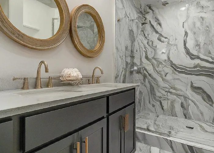 Salle de bain rénovée à Saint-Avertin : douche à l'italienne mosaïque travertin, paroi verre fixe, sol imitation bois, niche encastrée LED